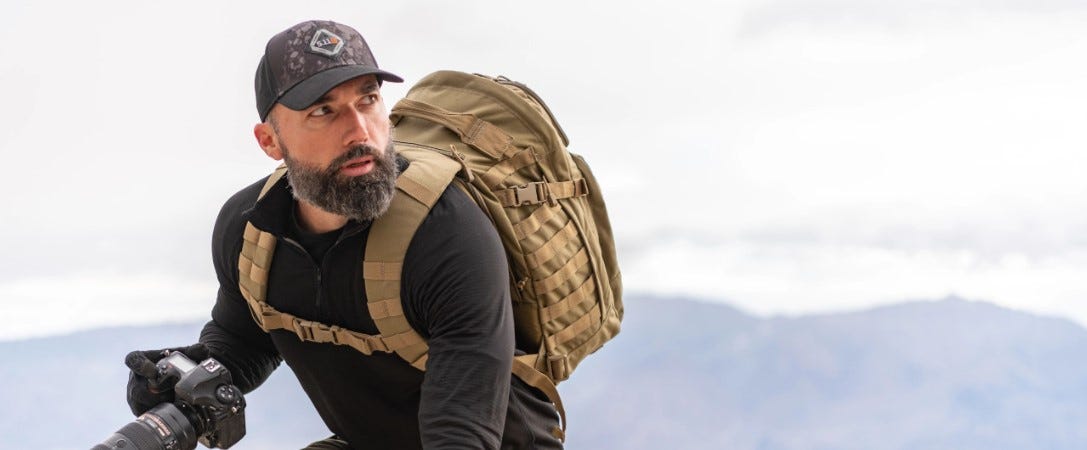 photo of a man wearing a trucker hat out in the wilderness.