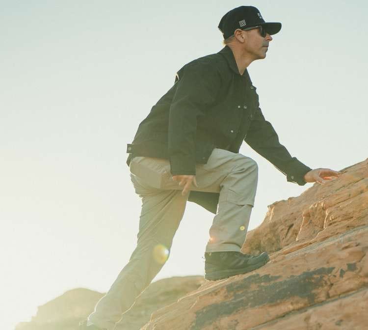 Man climbs a hill wearing the Industry Pant