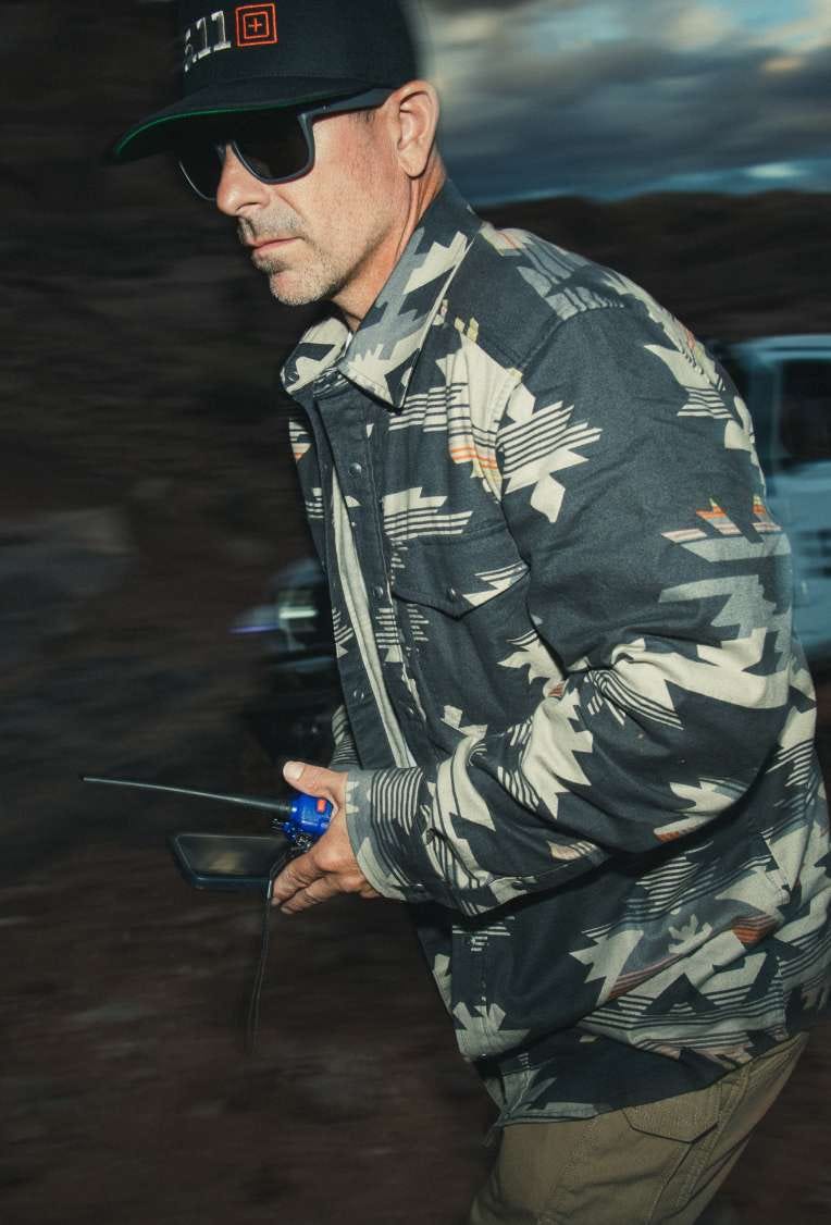 Man wearing patterned flannel and sunglasses