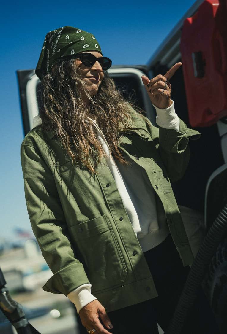 Woman in a bandana and Rosser Jacket stands beside an off-road vehicle
