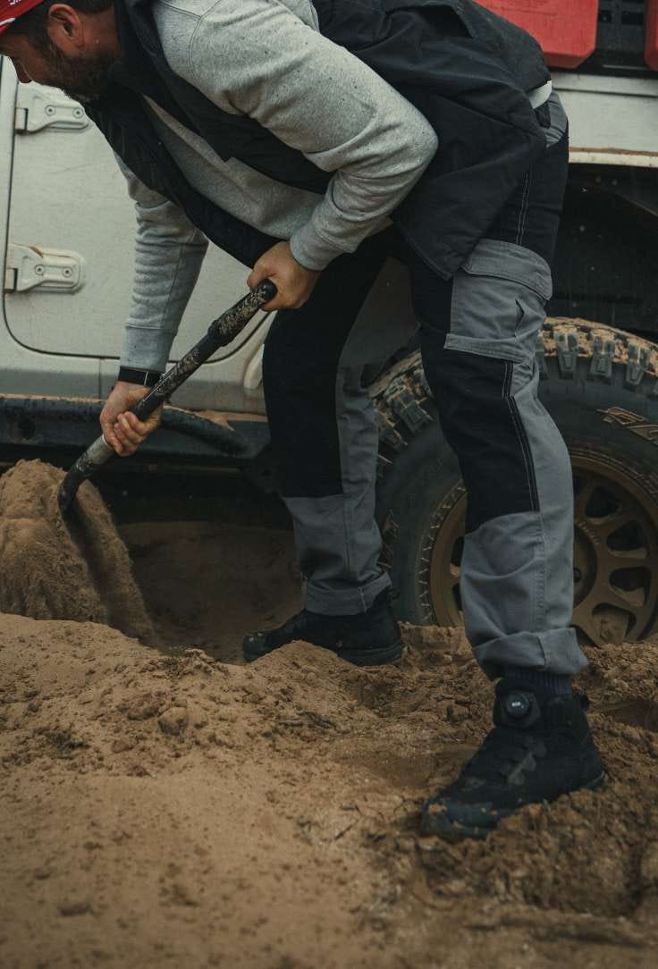 Man digs out the back wheel of a vehicle