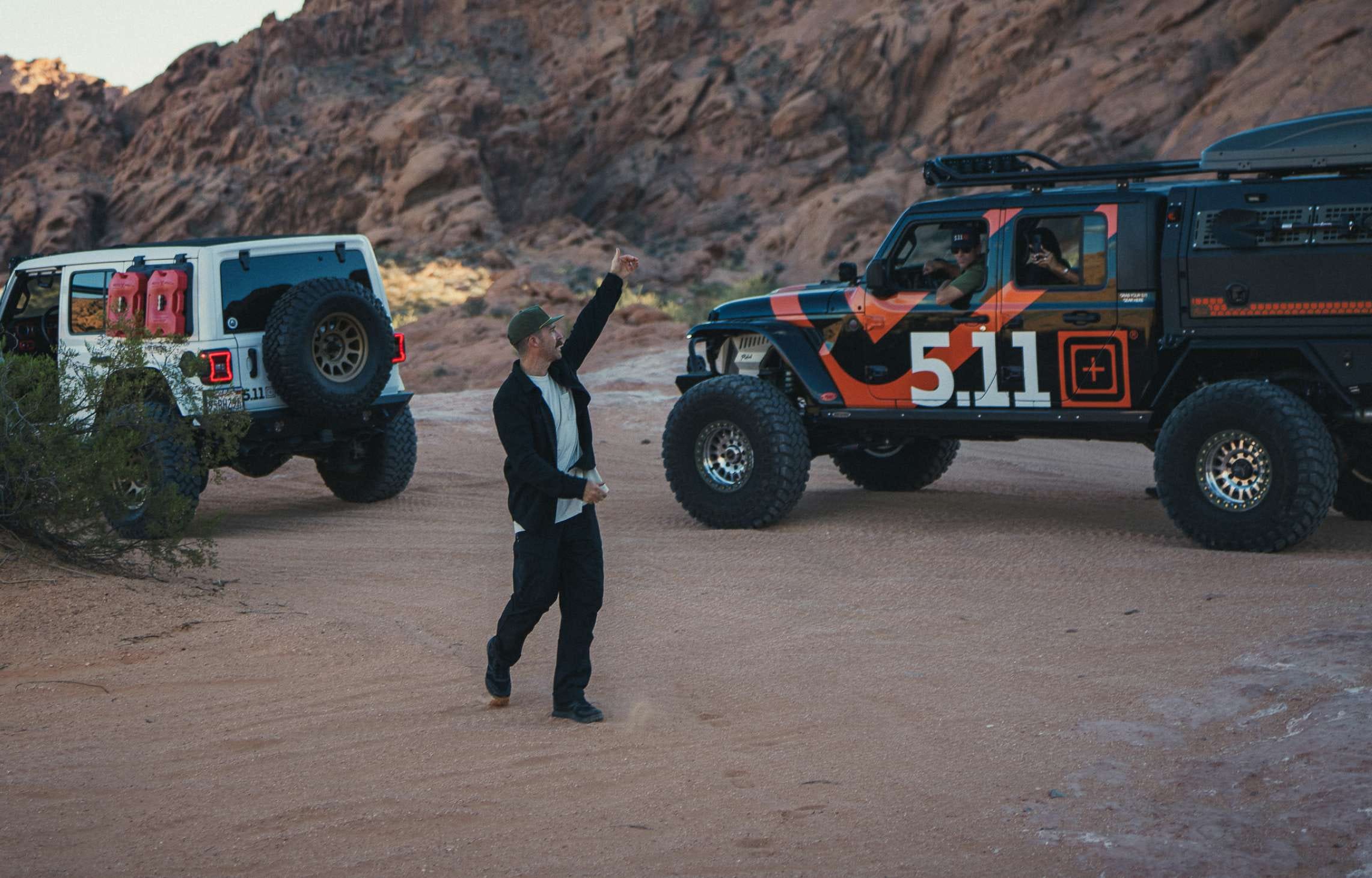 Man wearing 5.11 apparel walks around a desert landscape with off road vehicles