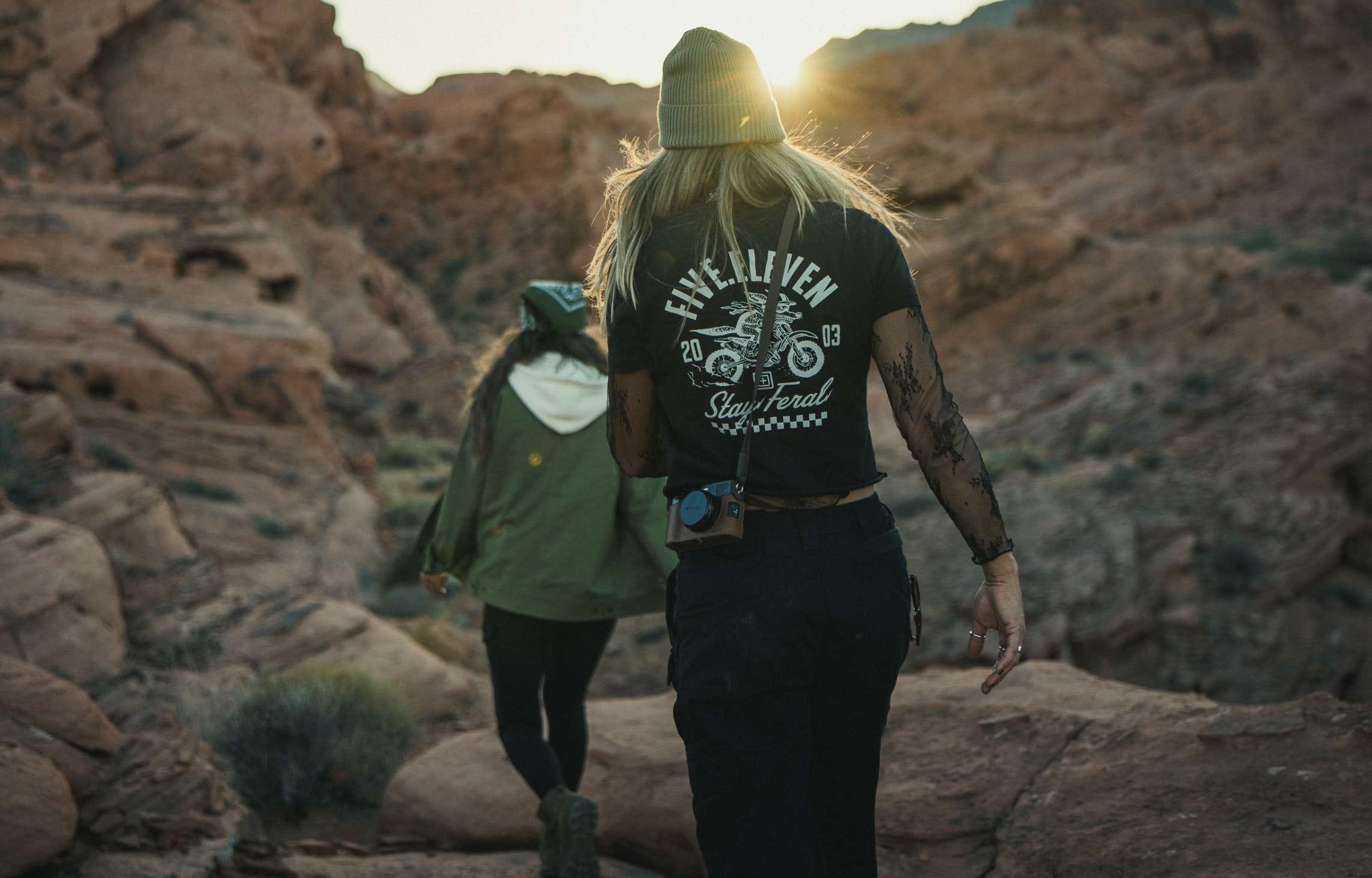 Two women walk through a rocky landscape
