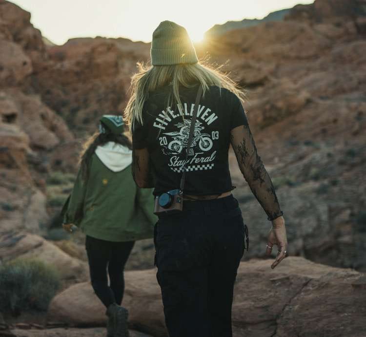 Two women walk through a rocky landscape