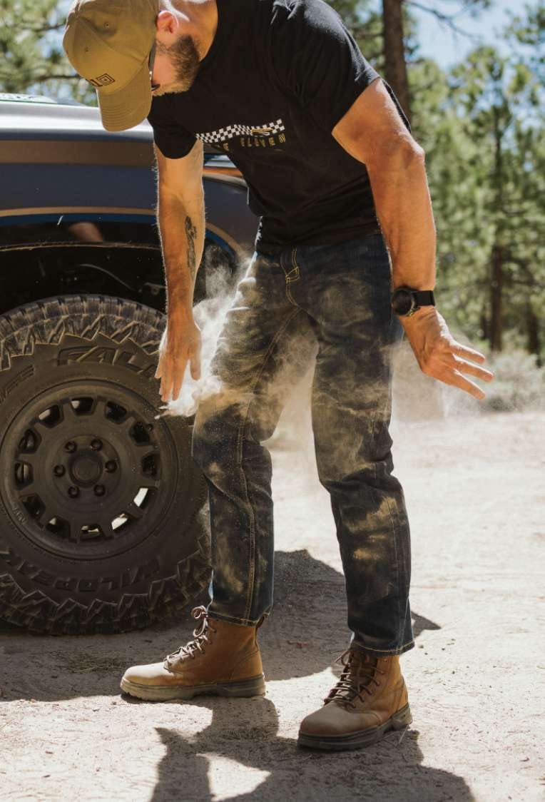 Man brushes dirt off jeans