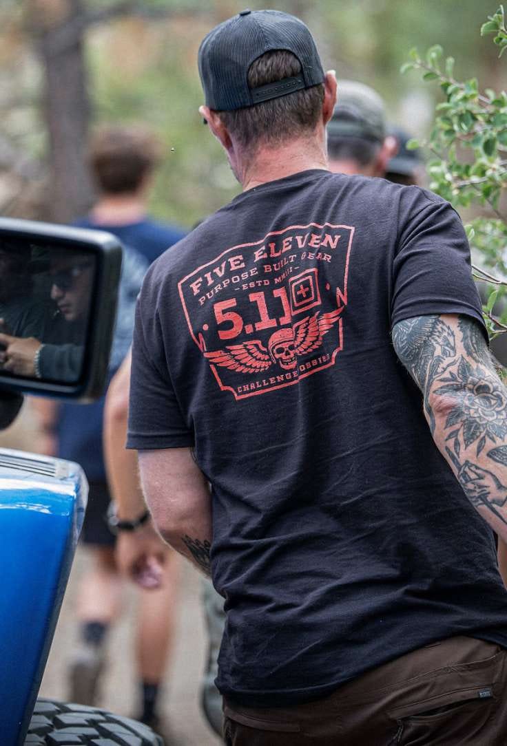 Man walking away in a black tshirt and hat