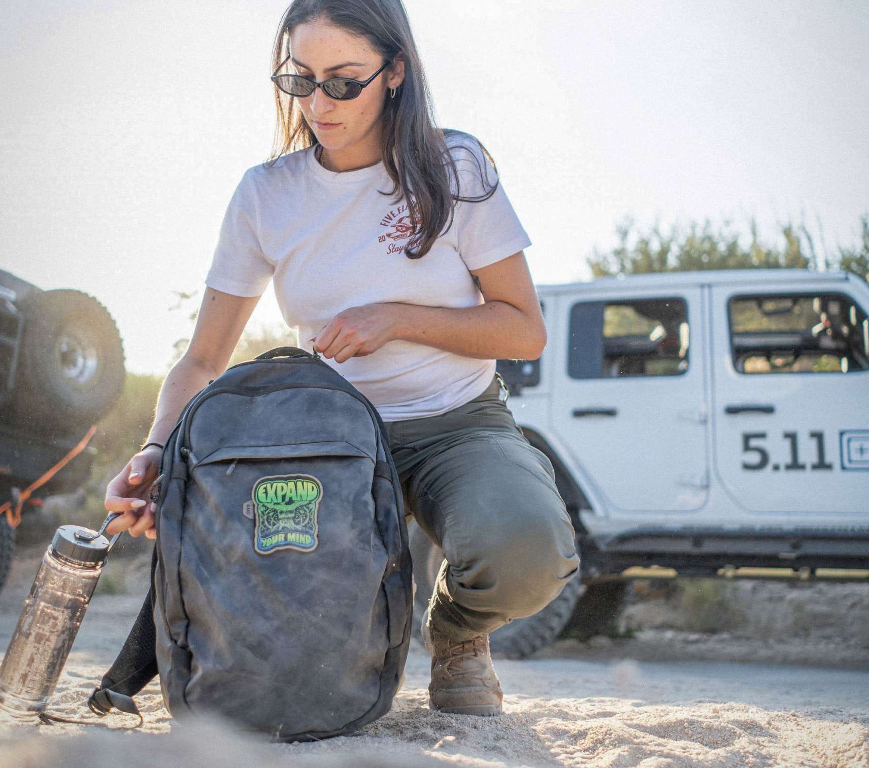 Woman kneeling loading up backpack