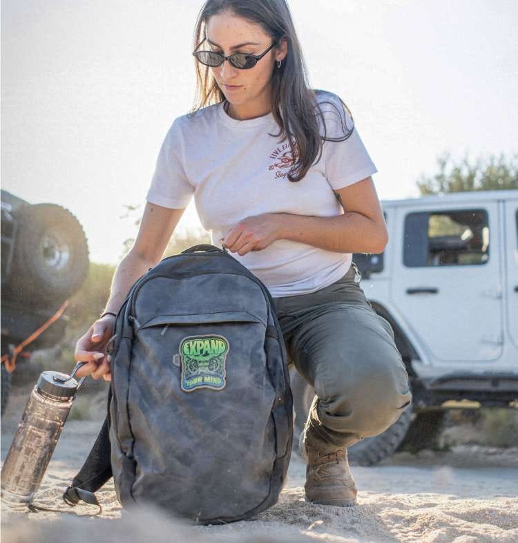 Woman kneeling loading up backpack