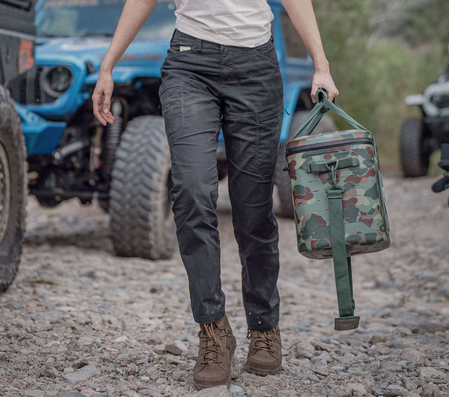 Woman walking in black pants holding a cooler