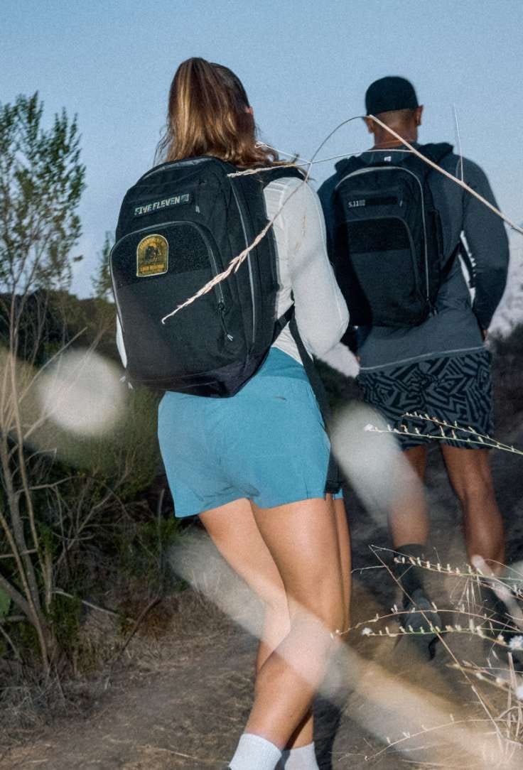 Man and woman wearing ruck packs running
