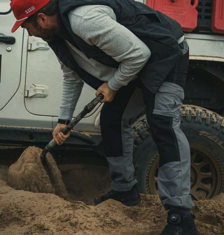 Man wearing khaki pants digging in dirt