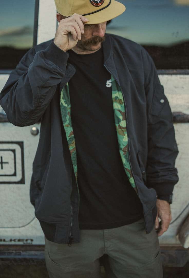 Man in jacket tipping his hat
