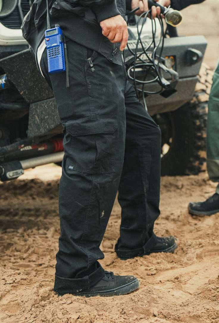 Man standing in sand with wire in his hand
