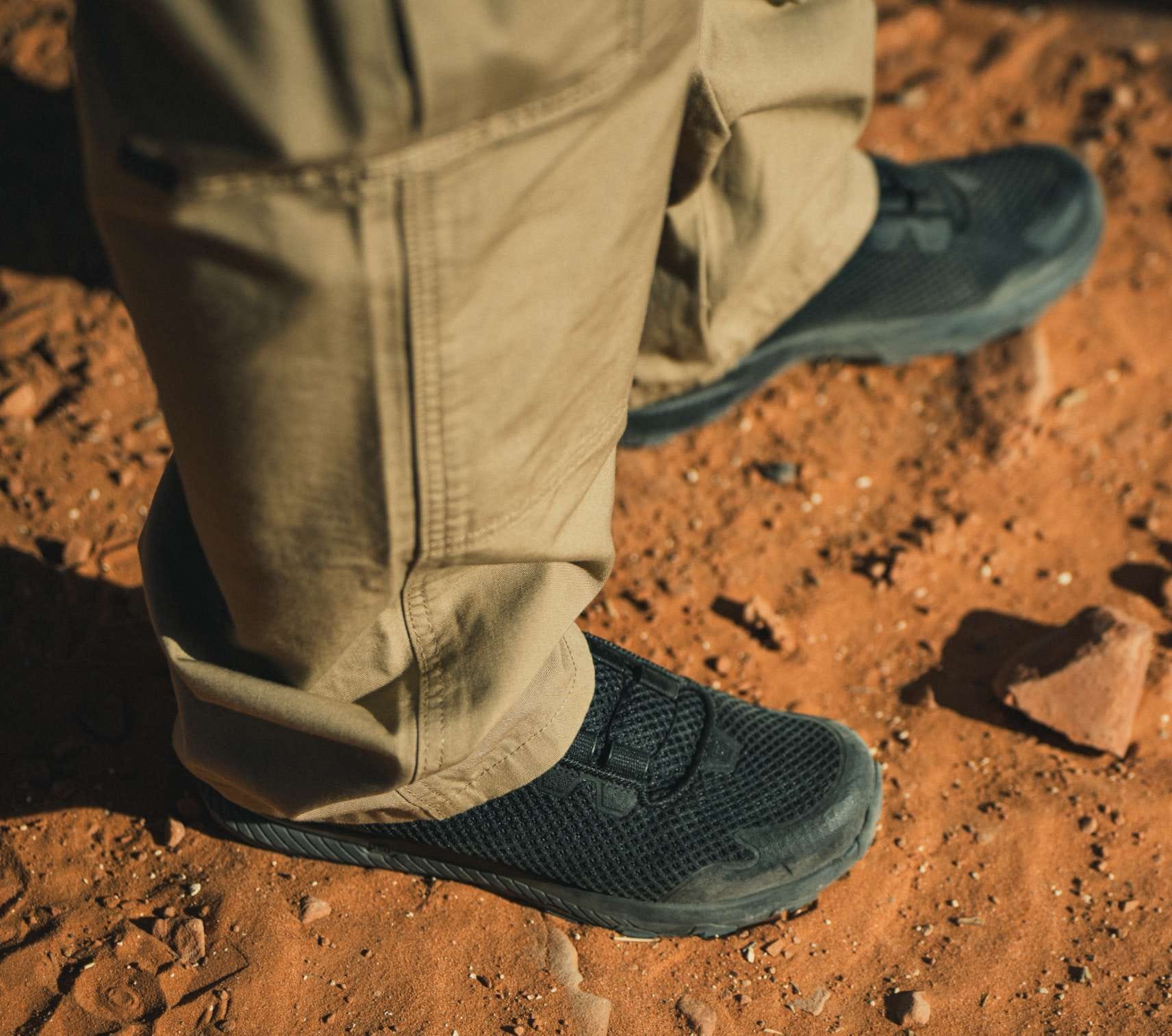 Man wearing khaki pants walking in dirt