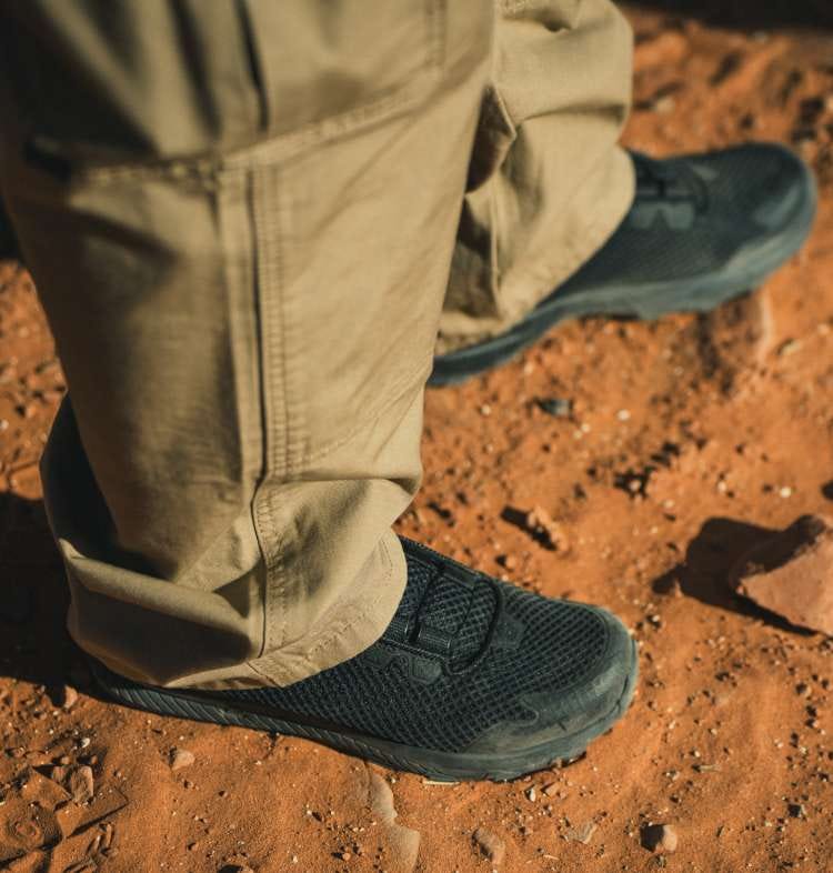 Man wearing khaki pants walking in dirt