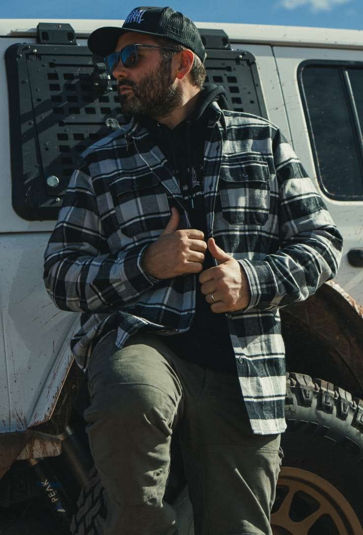 Man in flannel leaning on car