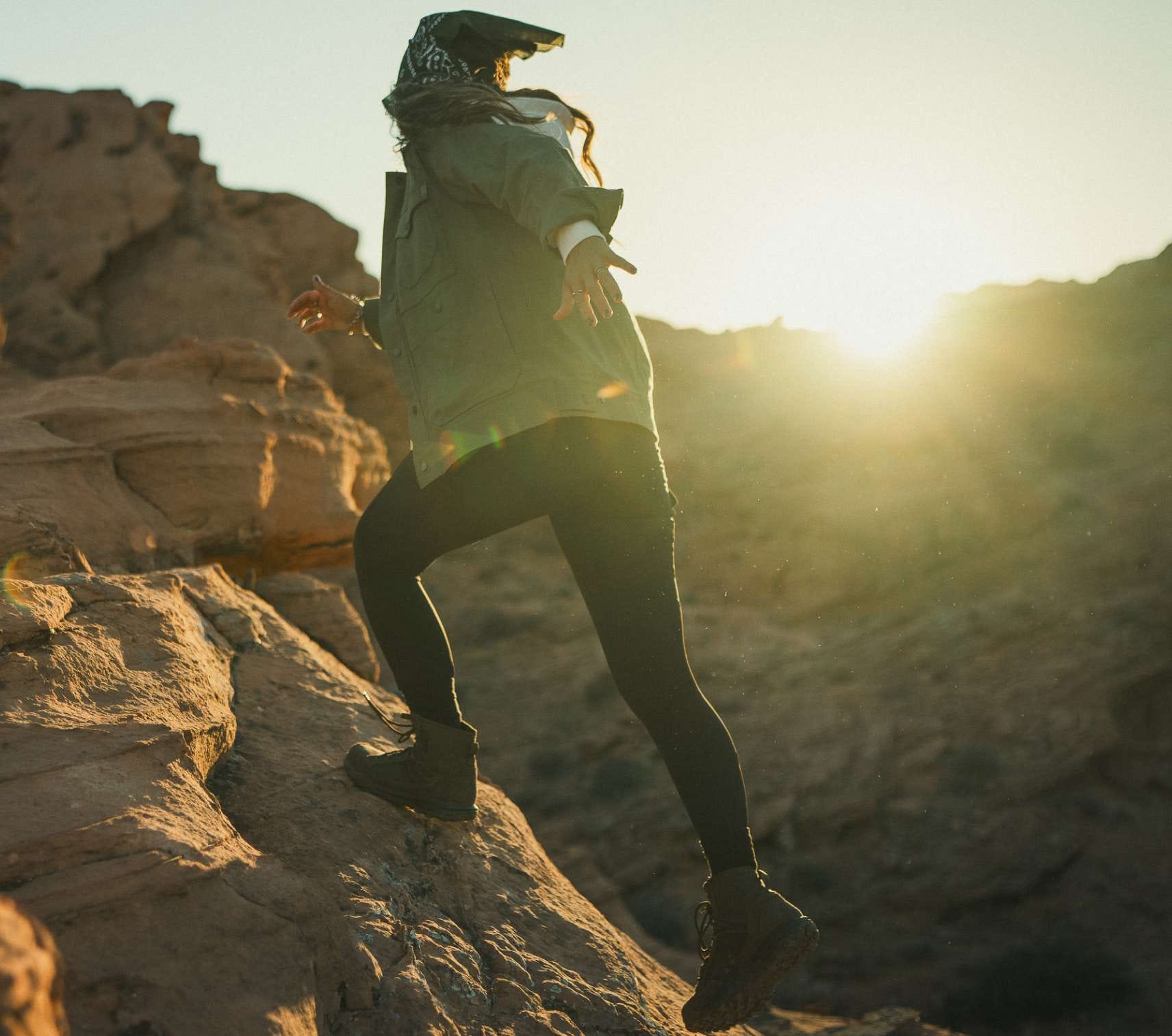 Woman wearing leggings walking up rocks 