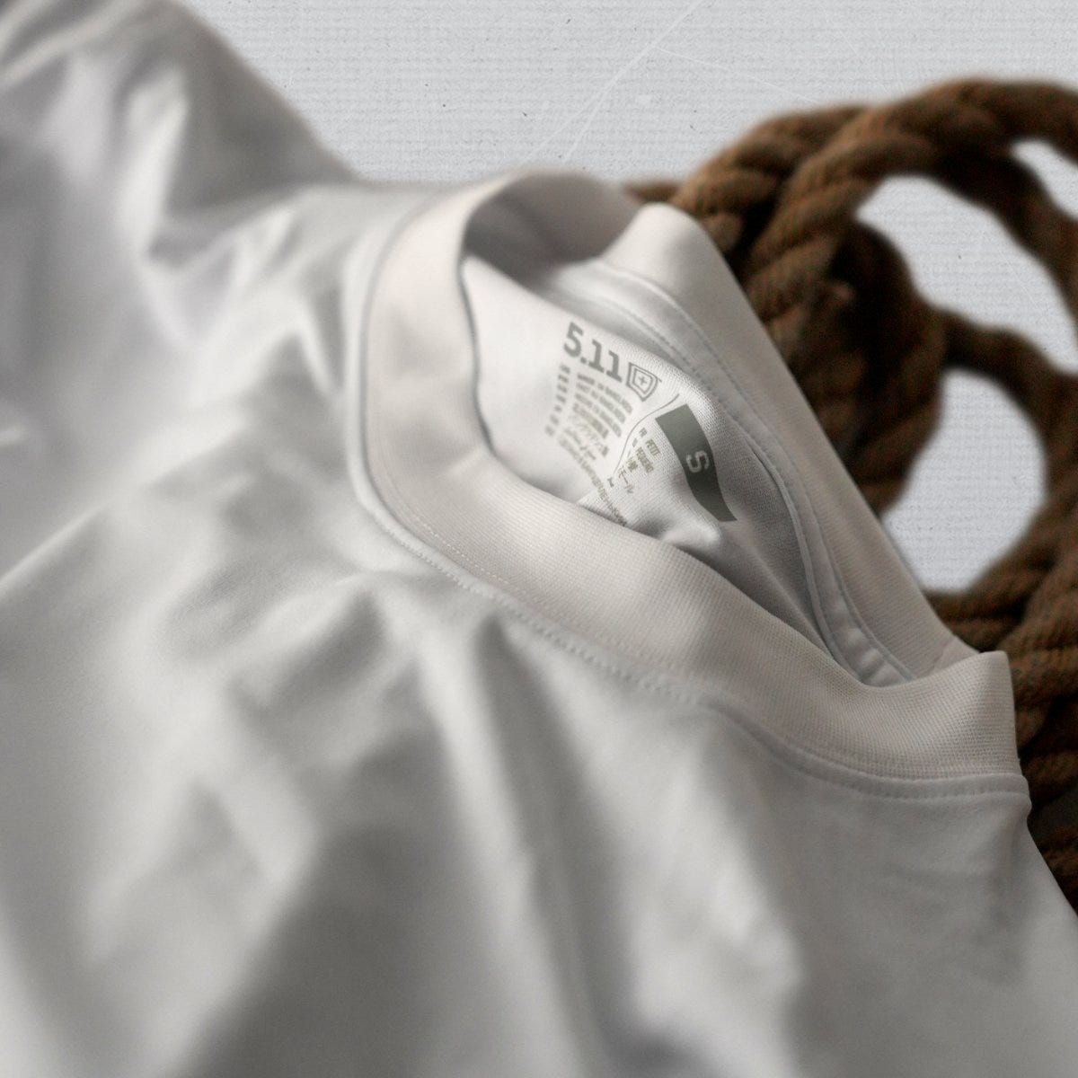 A white performance tee on a rope.