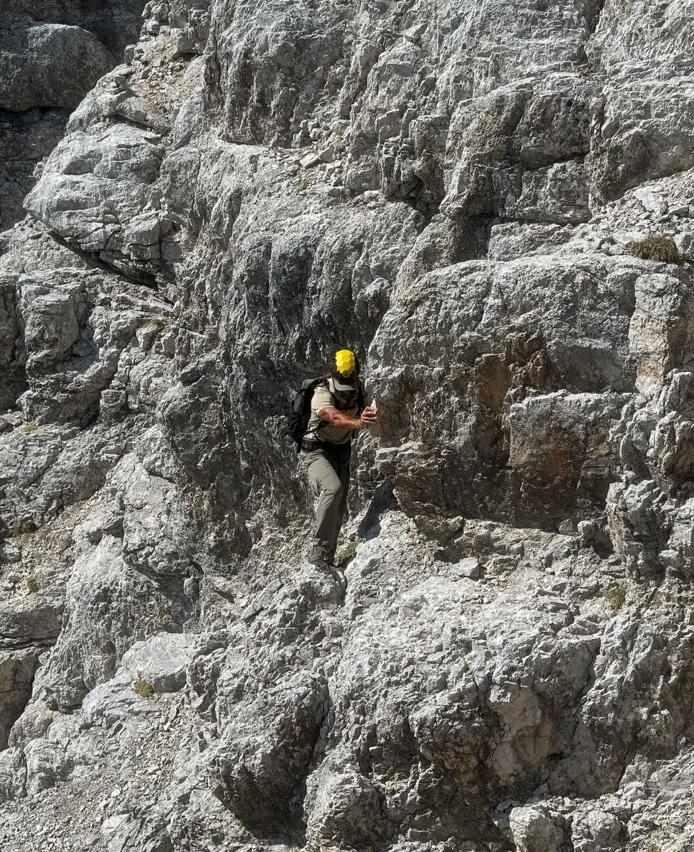 Luca Fois scatta un selfie ai piedi di una montagna.