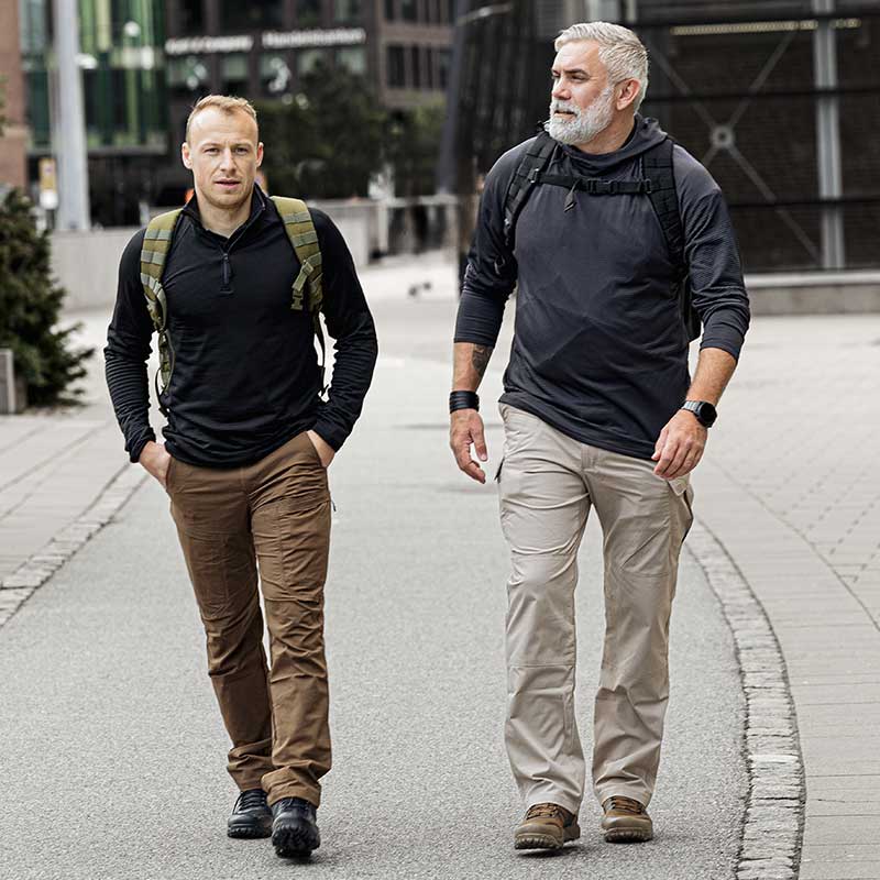 Zwei M&auml;nner in taktischer Kleidung gehen durch die Stadt.